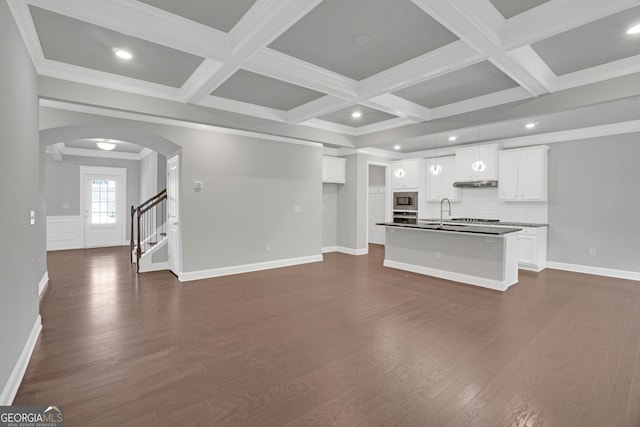 7043 Lancaster Xing, Flowery Branch, GA 30542 - unfurnished living room with arched walkways, coffered ceiling, dark wood-type flooring, beamed ceiling, and recessed lighting