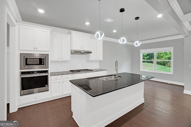 7043 Lancaster Xing, Flowery Branch, GA 30542 - kitchen featuring stainless steel appliances, under cabinet range hood, dark stone countertops, a kitchen island with sink, and backsplash