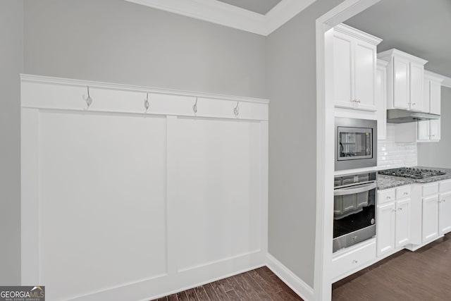 7043 Lancaster Xing, Flowery Branch, GA 30542 - kitchen with stainless steel appliances, crown molding, under cabinet range hood, dark wood-style floors, and light stone counters