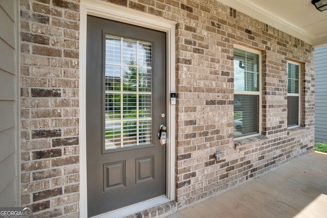 7043 Lancaster Xing, Flowery Branch, GA 30542 - doorway to property featuring brick siding