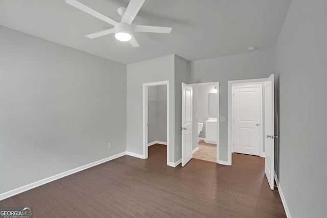 7043 Lancaster Xing, Flowery Branch, GA 30542 - unfurnished bedroom featuring dark wood finished floors, a walk in closet, a closet, and ceiling fan