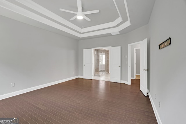 7043 Lancaster Xing, Flowery Branch, GA 30542 - unfurnished bedroom featuring a raised ceiling, dark wood finished floors, and ceiling fan