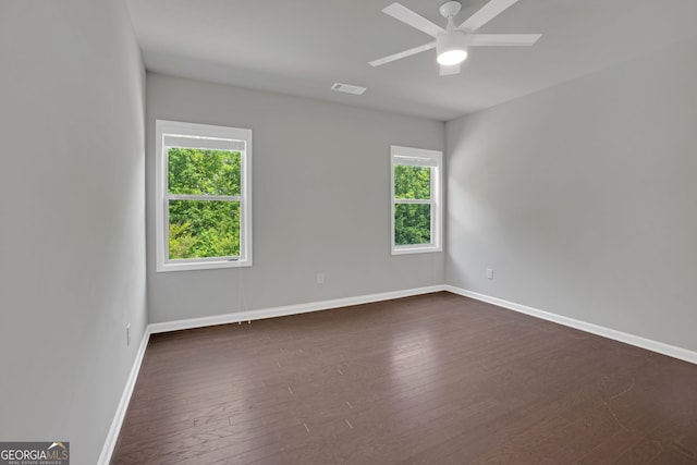 7043 Lancaster Xing, Flowery Branch, GA 30542 - empty room with healthy amount of natural light, dark wood-style floors, and ceiling fan