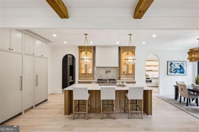 1312 Becket Dr NE, Brookhaven, GA 30319 - kitchen with arched walkways, beamed ceiling, light wood finished floors, backsplash, and recessed lighting