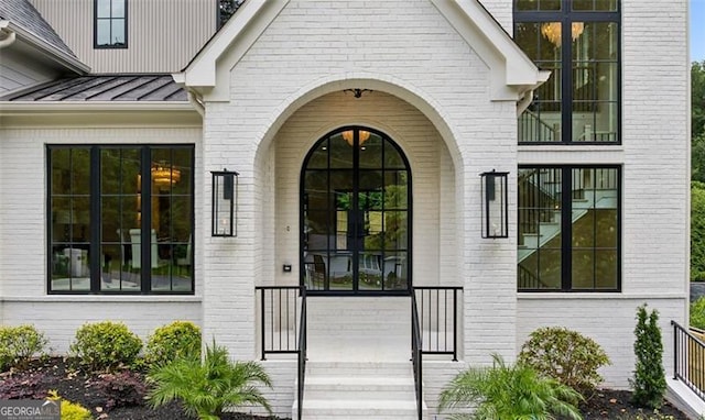 1312 Becket Dr NE, Brookhaven, GA 30319 - view of exterior entry featuring brick siding and a standing seam roof