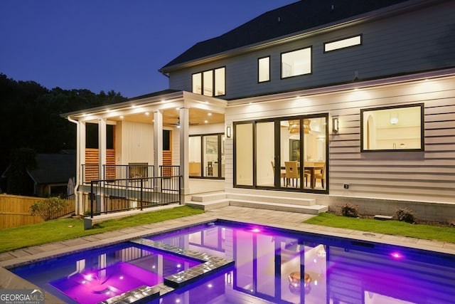 1312 Becket Dr NE, Brookhaven, GA 30319 - back of house at night featuring a pool with connected hot tub and a patio area