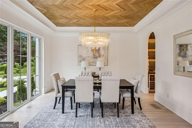 1312 Becket Dr NE, Brookhaven, GA 30319 - dining space with a chandelier, a tray ceiling, arched walkways, and wood finished floors