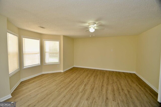 1824 Cedar Shoals Dr, Athens, GA 30605 - spare room with wood finished floors, ceiling fan, and a textured ceiling