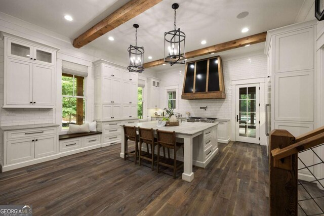 13365 Hopewell Rd, Alpharetta, GA 30004 - kitchen featuring white cabinetry, dark wood-type flooring, tasteful backsplash, a breakfast bar, and beamed ceiling