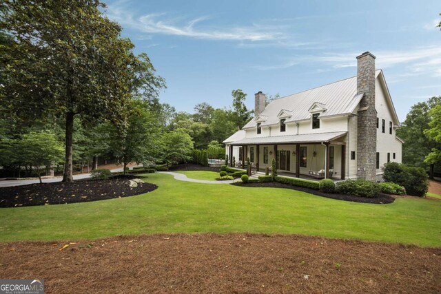 13365 Hopewell Rd, Alpharetta, GA 30004 - back of property with a chimney, a lawn, a porch, and a metal roof