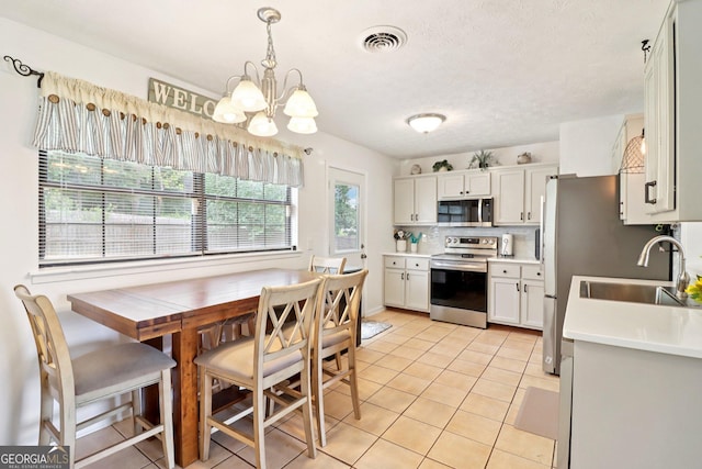 956 Euharlee Rd SW, Cartersville, GA 30120 - kitchen featuring appliances with stainless steel finishes, a chandelier, light tile patterned flooring, and light countertops