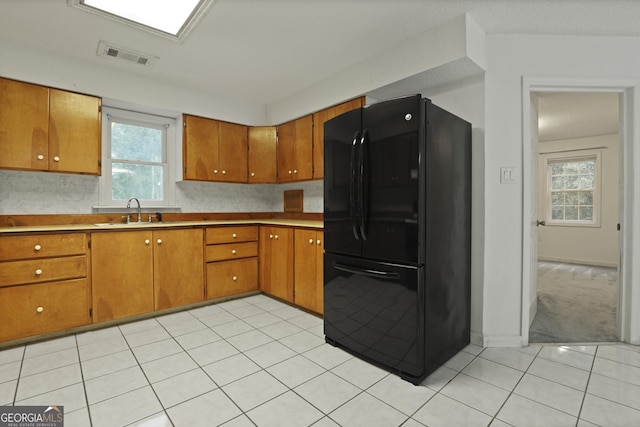 684 Frances Ln, Brooklet, GA 30415 - kitchen featuring freestanding refrigerator, brown cabinets, light tile patterned flooring, and light countertops
