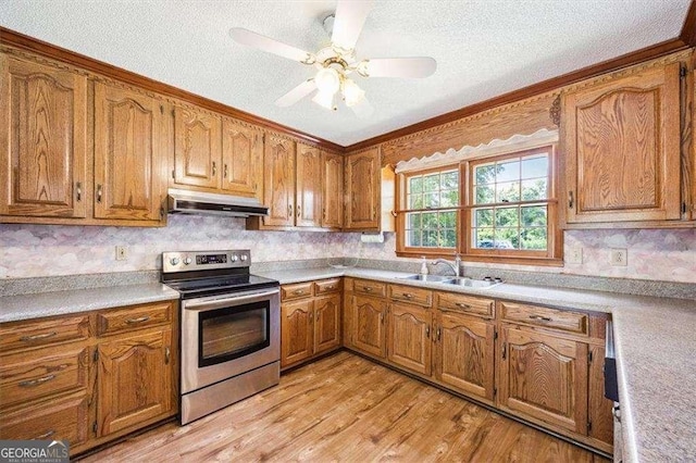 204 Old Oak Rd, Macon, GA 31216 - kitchen featuring electric range, under cabinet range hood, brown cabinetry, a textured ceiling, and light wood-style floors