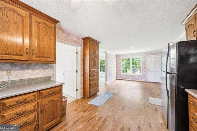 204 Old Oak Rd, Macon, GA 31216 - kitchen with freestanding refrigerator, brown cabinets, light wood-type flooring, a textured ceiling, and tasteful backsplash