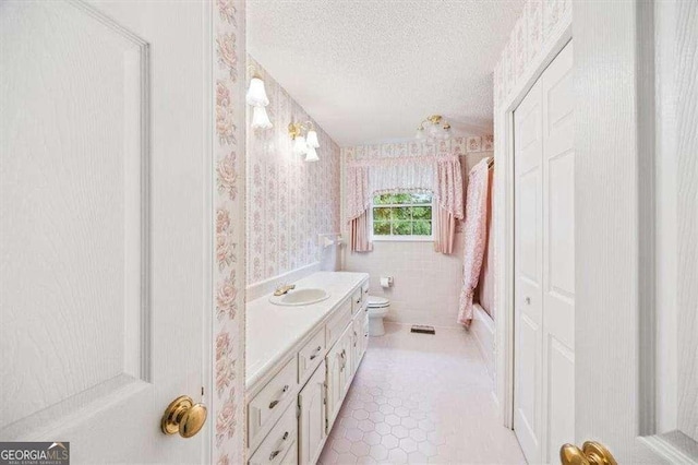 204 Old Oak Rd, Macon, GA 31216 - bathroom with a textured ceiling, vanity, wallpapered walls, shower / bath combo with shower curtain, and tile patterned floors