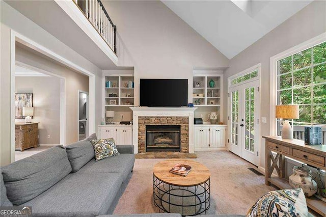 501 Avery Creek Pointe, Woodstock, GA 30188 - living room featuring high vaulted ceiling, built in features, a stone fireplace, french doors, and light carpet