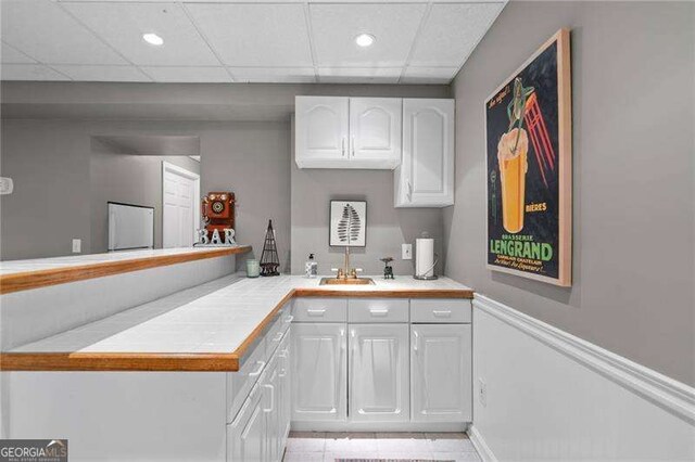 501 Avery Creek Pointe, Woodstock, GA 30188 - kitchen with white cabinets, light tile patterned floors, recessed lighting, tile countertops, and a peninsula