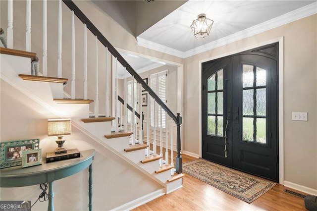 501 Avery Creek Pointe, Woodstock, GA 30188 - foyer entrance with ornamental molding, french doors, wood finished floors, plenty of natural light, and stairway
