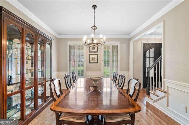 501 Avery Creek Pointe, Woodstock, GA 30188 - dining room featuring a chandelier, a decorative wall, a wainscoted wall, light wood finished floors, and ornamental molding