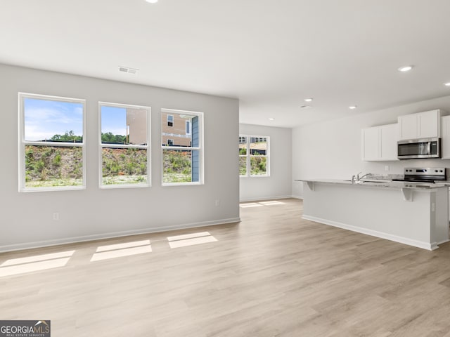 504 Oak View Ln, Dallas, GA 30157 - kitchen with stainless steel appliances, open floor plan, recessed lighting, white cabinetry, and light wood finished floors