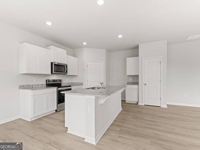 504 Oak View Ln, Dallas, GA 30157 - kitchen with stainless steel appliances, a kitchen island with sink, white cabinetry, light wood-style flooring, and recessed lighting