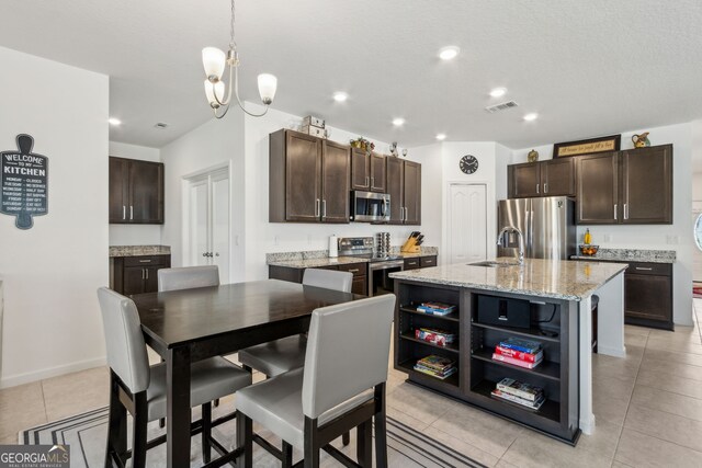 159 College St, Kingsland, GA 31548 - kitchen with stainless steel appliances, open shelves, dark brown cabinetry, light tile patterned floors, and recessed lighting