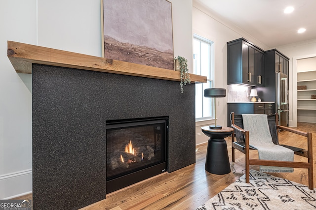 2164 James Aly, Atlanta, GA 30345 - living area featuring light wood-style flooring, crown molding, a glass covered fireplace, and recessed lighting