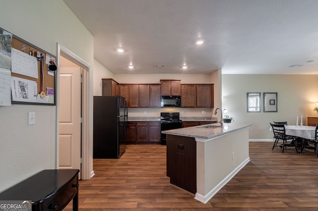 410 Meadowbend Cir, Athens, GA 30606 - kitchen featuring black appliances, dark wood-style flooring, light stone counters, recessed lighting, and a center island with sink