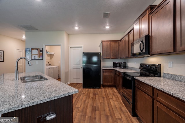 410 Meadowbend Cir, Athens, GA 30606 - kitchen featuring black appliances, washer and clothes dryer, light wood finished floors, light stone counters, and dark brown cabinetry