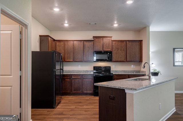 410 Meadowbend Cir, Athens, GA 30606 - kitchen featuring black appliances, wood finished floors, an island with sink, recessed lighting, and light stone counters