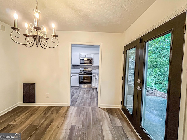 3150 Stratford Green Pl, Avondale Estates, GA 30002 - unfurnished dining area featuring a chandelier, dark wood-style floors, and a textured ceiling