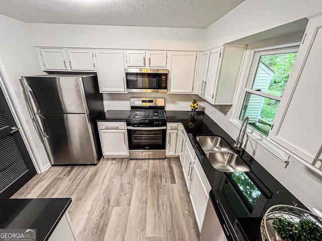 3150 Stratford Green Pl, Avondale Estates, GA 30002 - kitchen with stainless steel appliances, dark countertops, light wood finished floors, tasteful backsplash, and white cabinets