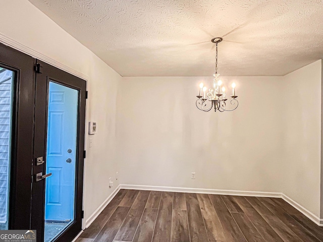 3150 Stratford Green Pl, Avondale Estates, GA 30002 - unfurnished dining area featuring dark wood-type flooring, a chandelier, and a textured ceiling