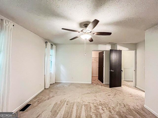 3150 Stratford Green Pl, Avondale Estates, GA 30002 - unfurnished bedroom with carpet, a textured ceiling, a walk in closet, and ceiling fan