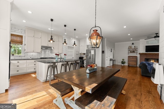 429 Hubert Harris Rd, Cornelia, GA 30531 - dining room with ceiling fan, a brick fireplace, recessed lighting, and light wood-type flooring
