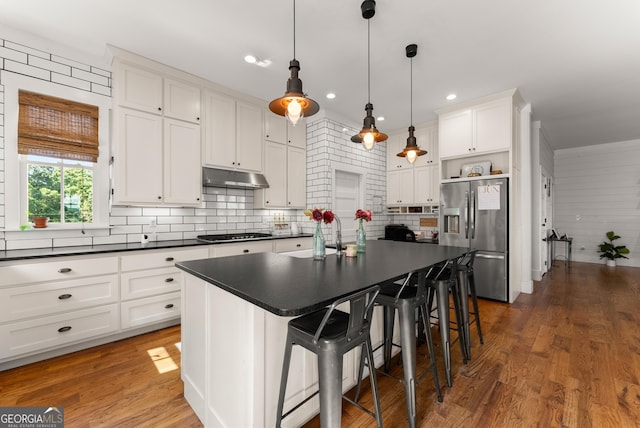 429 Hubert Harris Rd, Cornelia, GA 30531 - kitchen featuring appliances with stainless steel finishes, dark countertops, white cabinetry, tasteful backsplash, and under cabinet range hood