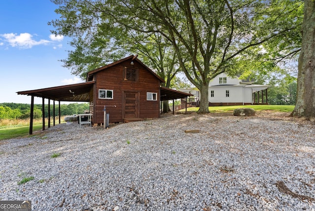 429 Hubert Harris Rd, Cornelia, GA 30531 - view of home's exterior with gravel driveway, an outdoor structure, and an attached carport