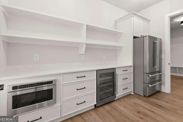 6750 Pannell Rd, Buford, GA 30518 - kitchen featuring stainless steel appliances, wine cooler, open shelves, light wood-style flooring, and white cabinetry