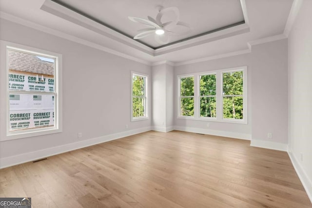 6750 Pannell Rd, Buford, GA 30518 - empty room with a raised ceiling, light wood-style flooring, ceiling fan, and crown molding
