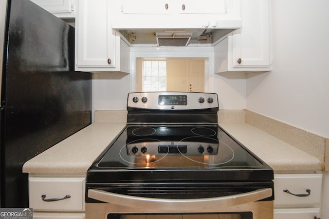 3101 Reeves St SE, Smyrna, GA 30080 - kitchen with stainless steel electric range, under cabinet range hood, white cabinets, light countertops, and freestanding refrigerator