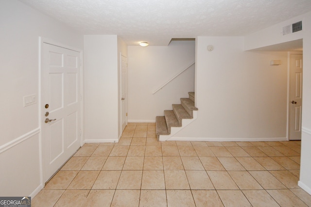 3101 Reeves St SE, Smyrna, GA 30080 - foyer entrance with a textured ceiling, stairs, and light tile patterned floors