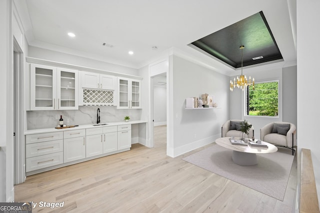 3061 Bold Springs Rd, Dacula, GA 30019 - indoor wet bar featuring light wood-type flooring, backsplash, a chandelier, pendant lighting, and ornamental molding