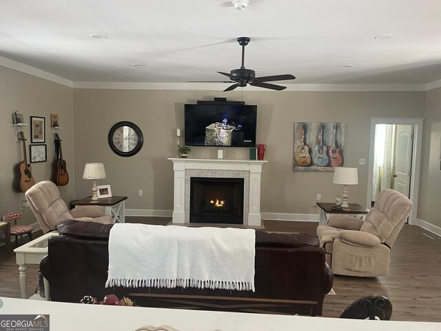 7191 Moontown Rd, Appling, GA 30802 - living room with wood finished floors, a ceiling fan, a warm lit fireplace, and crown molding