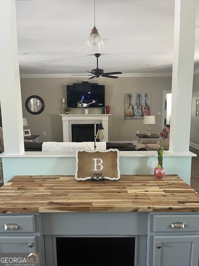 7191 Moontown Rd, Appling, GA 30802 - kitchen featuring butcher block counters, open floor plan, ornamental molding, a fireplace, and a ceiling fan