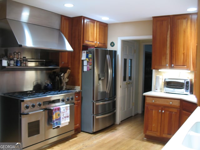 4098 Nancy Creek Way NE, Brookhaven, GA 30319 - kitchen with appliances with stainless steel finishes, wall chimney exhaust hood, light wood-style flooring, brown cabinetry, and recessed lighting