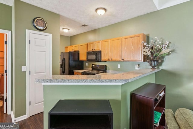 1714 Indian Way, Cumming, GA 30040 - kitchen with black appliances, dark wood finished floors, light brown cabinets, light countertops, and a peninsula