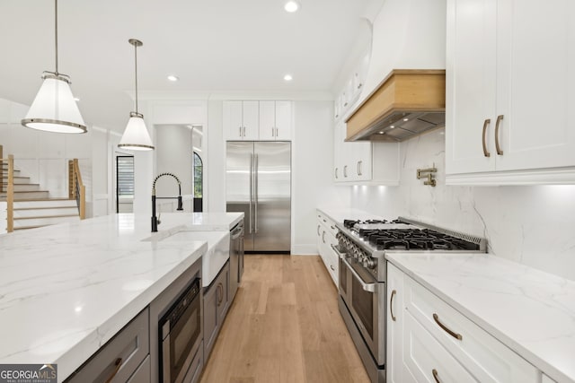 3735 Hamilton Mill Rd, Buford, GA 30519 - kitchen featuring built in appliances, premium range hood, light wood-style floors, tasteful backsplash, and recessed lighting