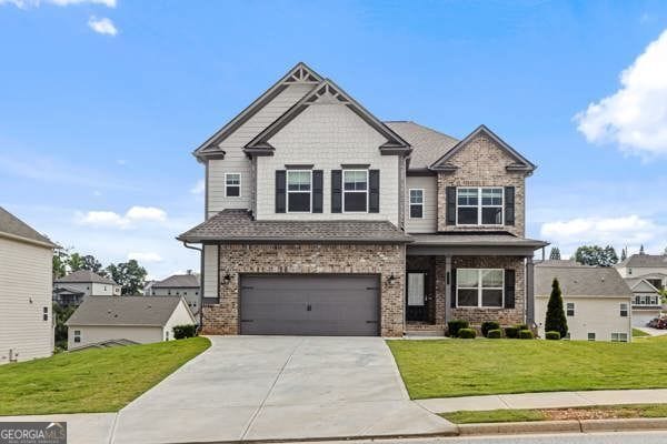 1494 Weeping Tree Cir, Hoschton, GA 30548 - craftsman-style home with driveway, brick siding, a front yard, and an attached garage