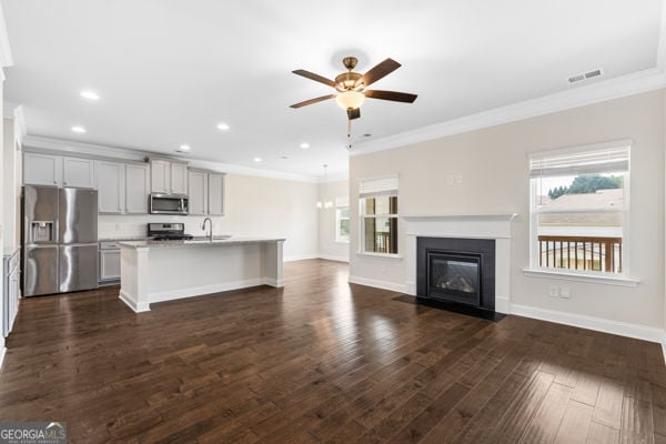 1494 Weeping Tree Cir, Hoschton, GA 30548 - unfurnished living room with ceiling fan, ornamental molding, recessed lighting, dark wood finished floors, and a fireplace with flush hearth