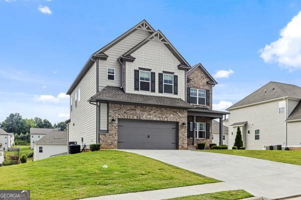 1494 Weeping Tree Cir, Hoschton, GA 30548 - craftsman-style home featuring driveway, an attached garage, a front lawn, and brick siding